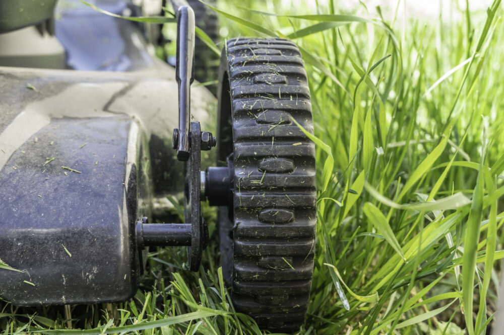 Wheels on electric lawn mower in garden to cut grass